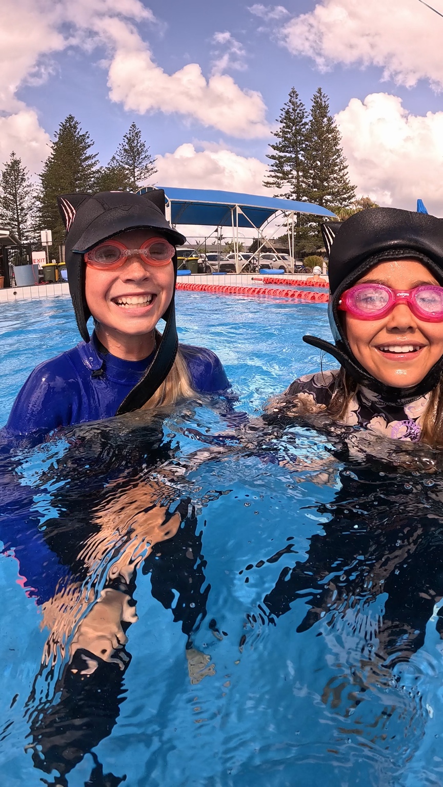 Two women smiling together during a supported pool session