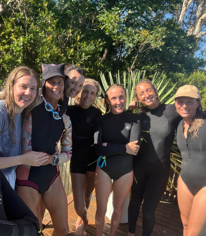 A group of women smiling together after time in the water