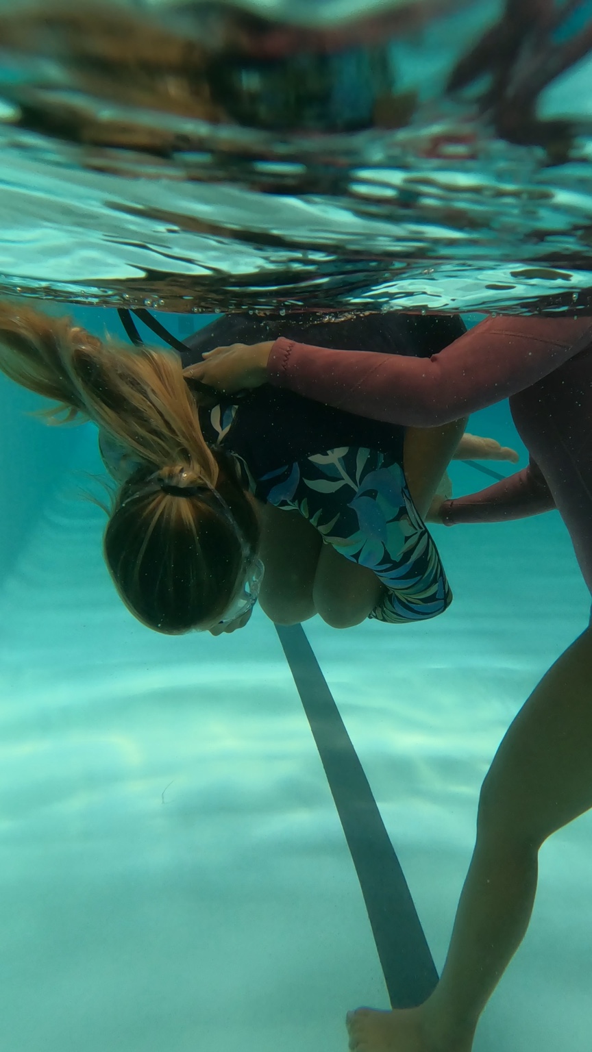 A participant practising composure through a supported underwater spinning exercise